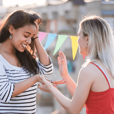 Lesbian couple exchanging engagement ring in the middle of  a marriage proposal